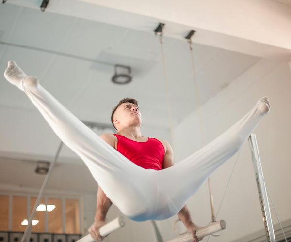 A man performing a controlled strength exercise in a bright, clean environment.